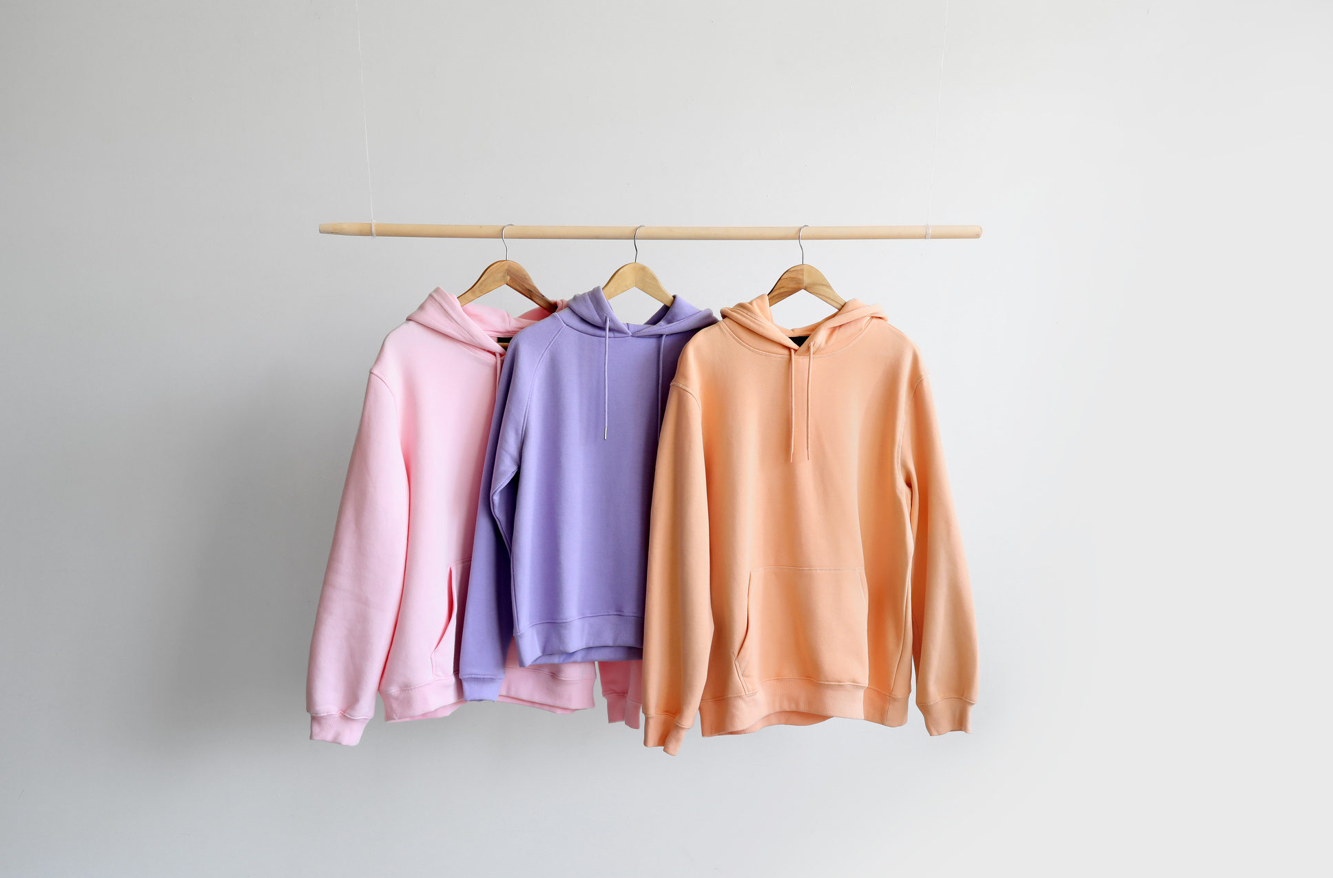 Modern Hoodies Hanging on Light Wall